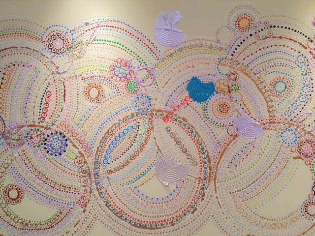A wall with many circles and dots painted on it
